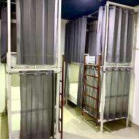 Curtained dorm bunk beds with ladders and individual storage
